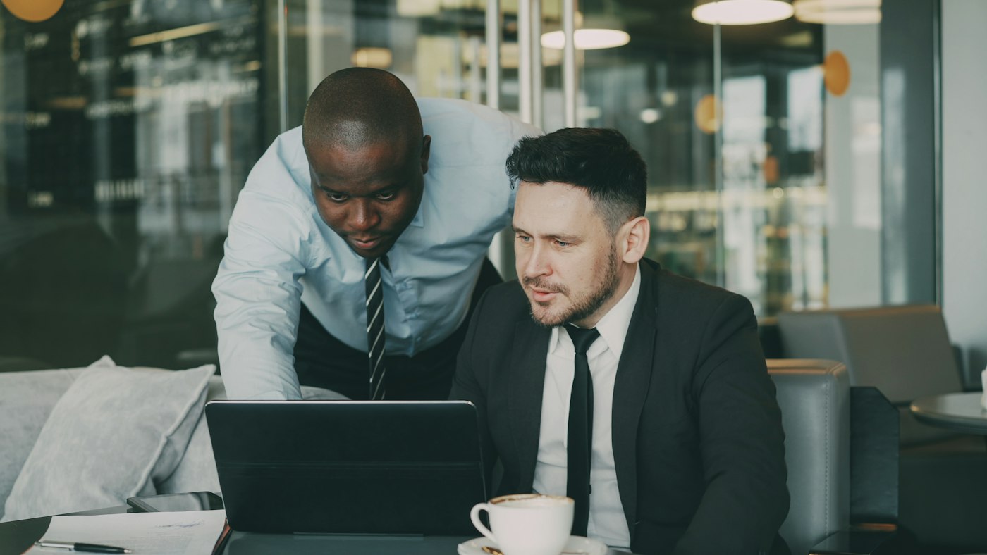 Two colleagues reviewing information together on a laptop
