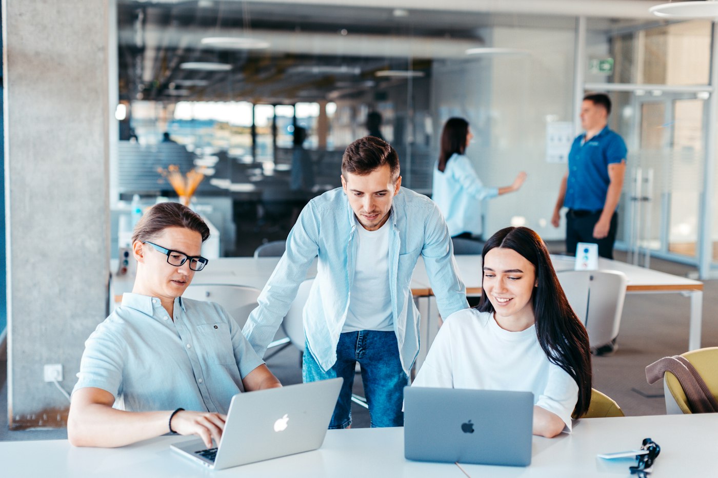 A team collaborating around laptops in a modern office